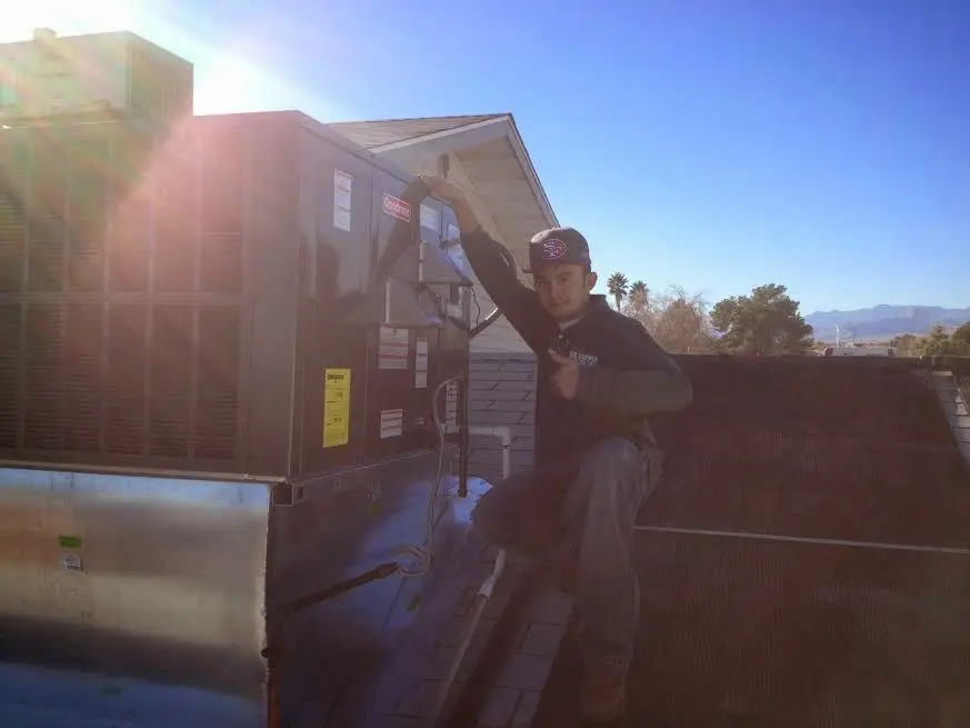 HVAC technician performing Air Duct Cleaning on a rooftop unit in Brandon